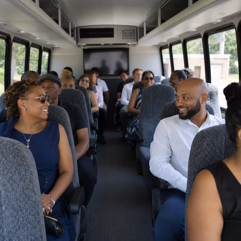Group boarding a white charter bus for Private Event Transportation transportation in Boston