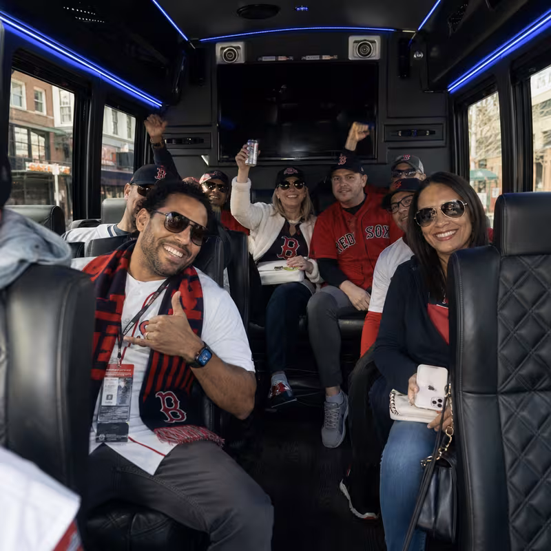 Group boarding a white charter bus for Sporting Event Transportation transportation in Boston