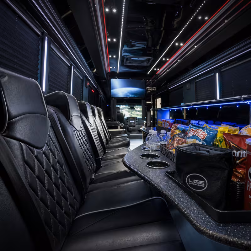 Party bus interior with wraparound leather seating and LED lighting in Boston